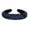 Polstret mørkeblå hårbøjle med sorte perler i mønster.