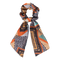 Angela Multi Scrunchie – orange scrunchie med mønstret tørklædee fekt, ideel til en elegant frisure.