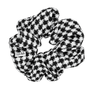 Sort og hvid pied-de-poule mønstret Pop Scrunchie håraccessory lavet i blødt polyesterstof.