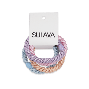 4-Pack Basic Essentials Elastics – sæt med fire hårelastikker i lyselilla, lyseorange, lyseblå og lyserød. Skånsomme og perfekte til alle frisurer.